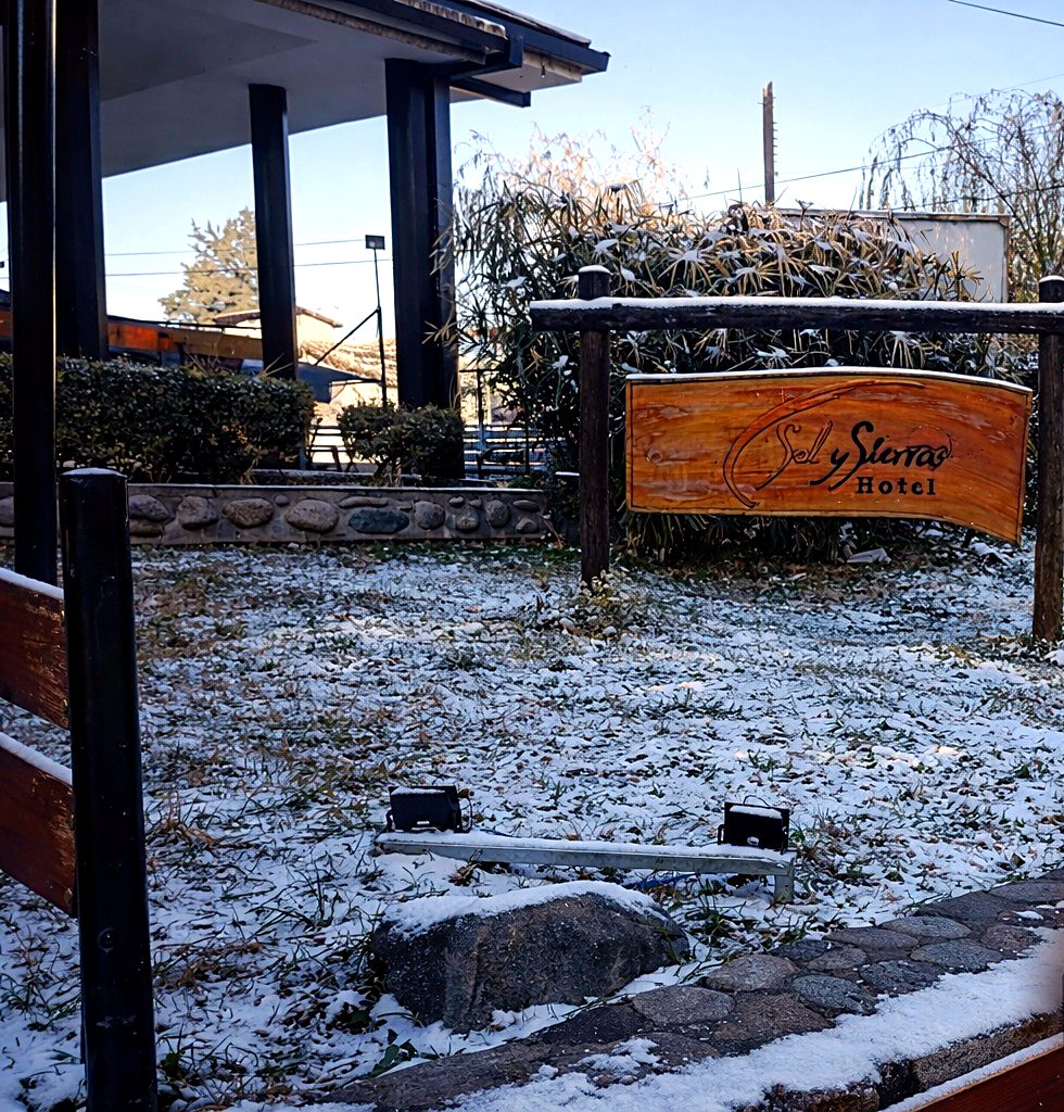 Nieve en el jardín de la entrada del hotel